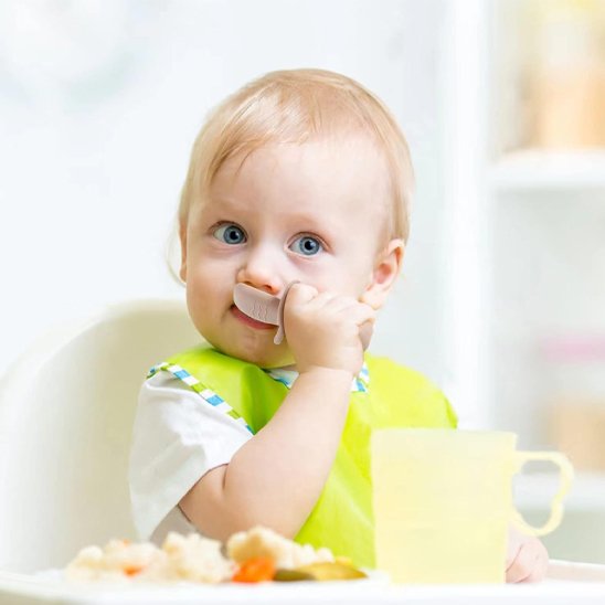 Couvert bébé beige clair, bébé utilise ses premiers couverts