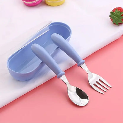 Couverts bébé bleu, posé sur une table avec sa boite de rangement