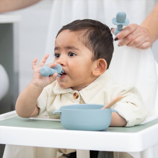 Couvert bébé​ bleu , bébé porte sa fourchette a la bouche