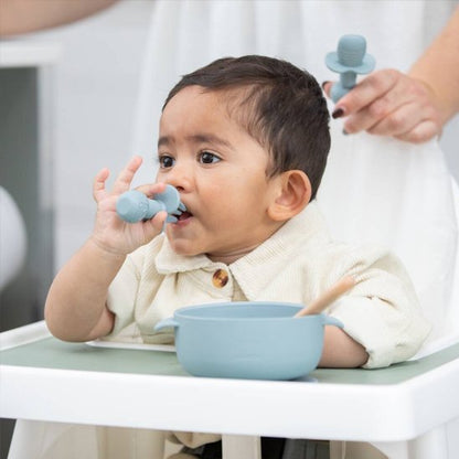 Couvert bébé​ bleu , bébé porte sa fourchette a la bouche